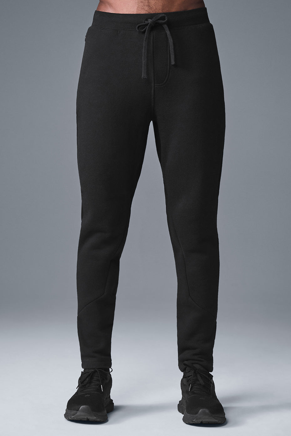 Close-up of black essentials sweatpants showing fleece texture and drawcord detail
