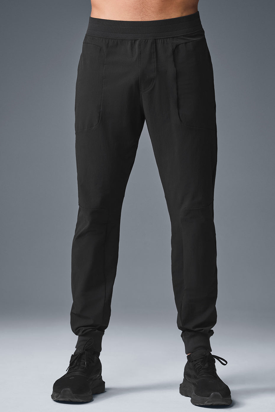 Side view of black fitness pants showcasing elastic waistband and pockets.