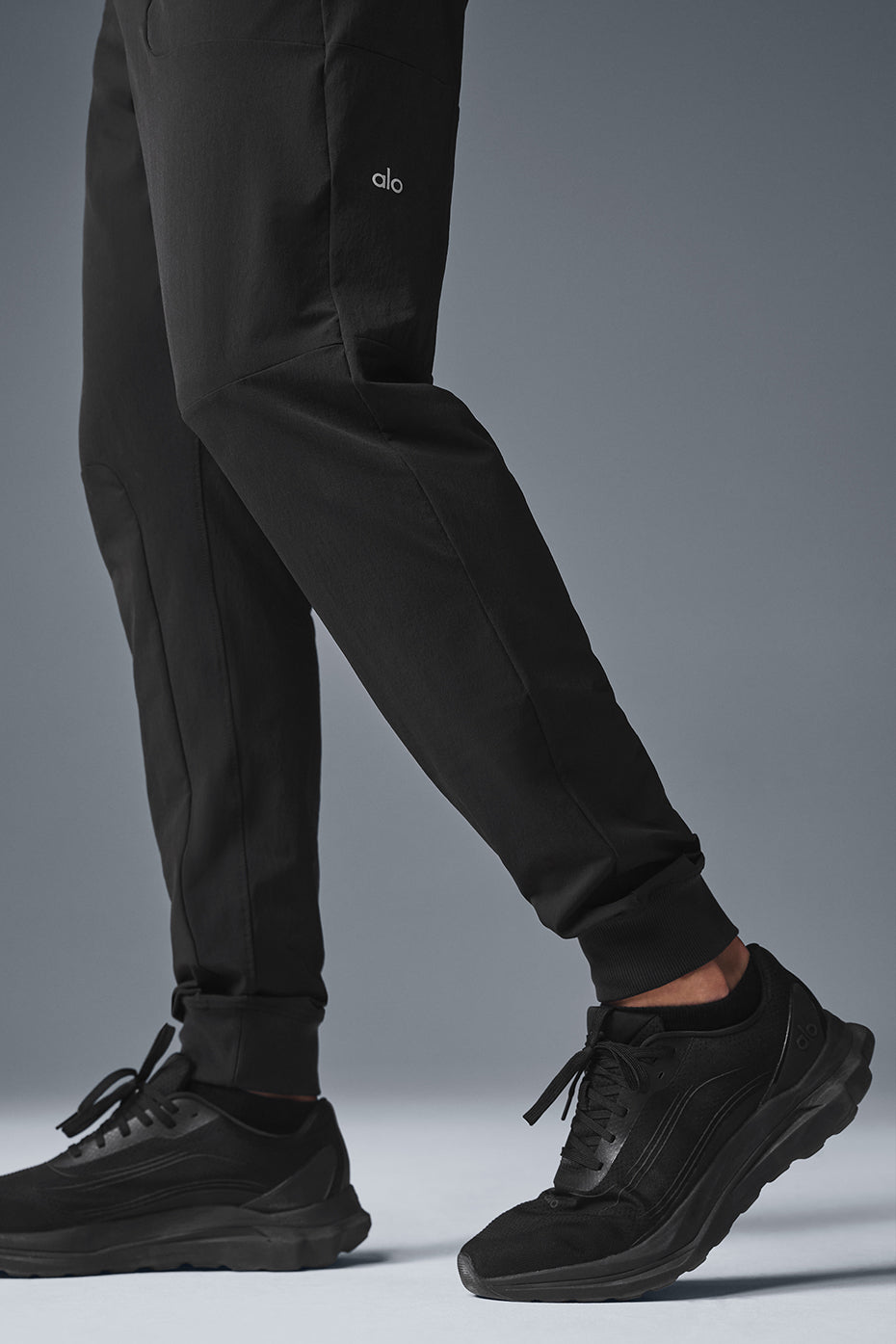 Side view of black fitness pants showcasing elastic waistband and pockets.