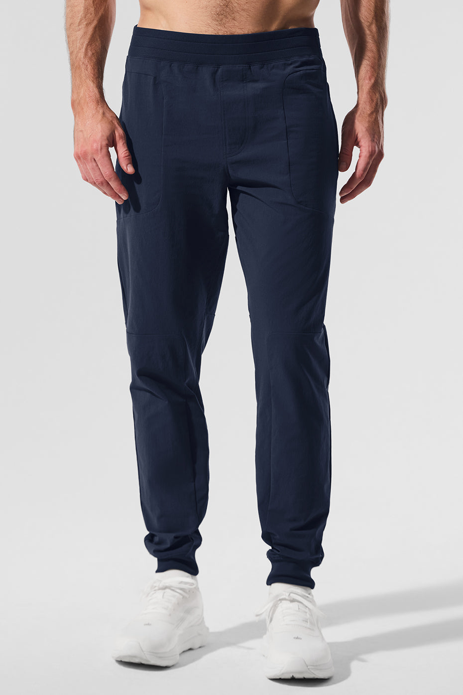 High-performance men's athletic pants in navy, showcasing side-zip pockets.