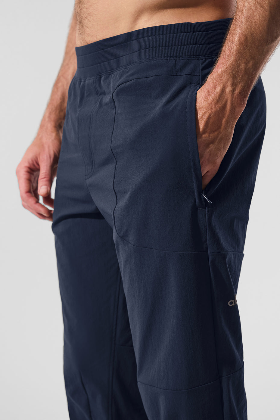 High-performance mens athletic pants in navy, showcasing side-zip pockets.