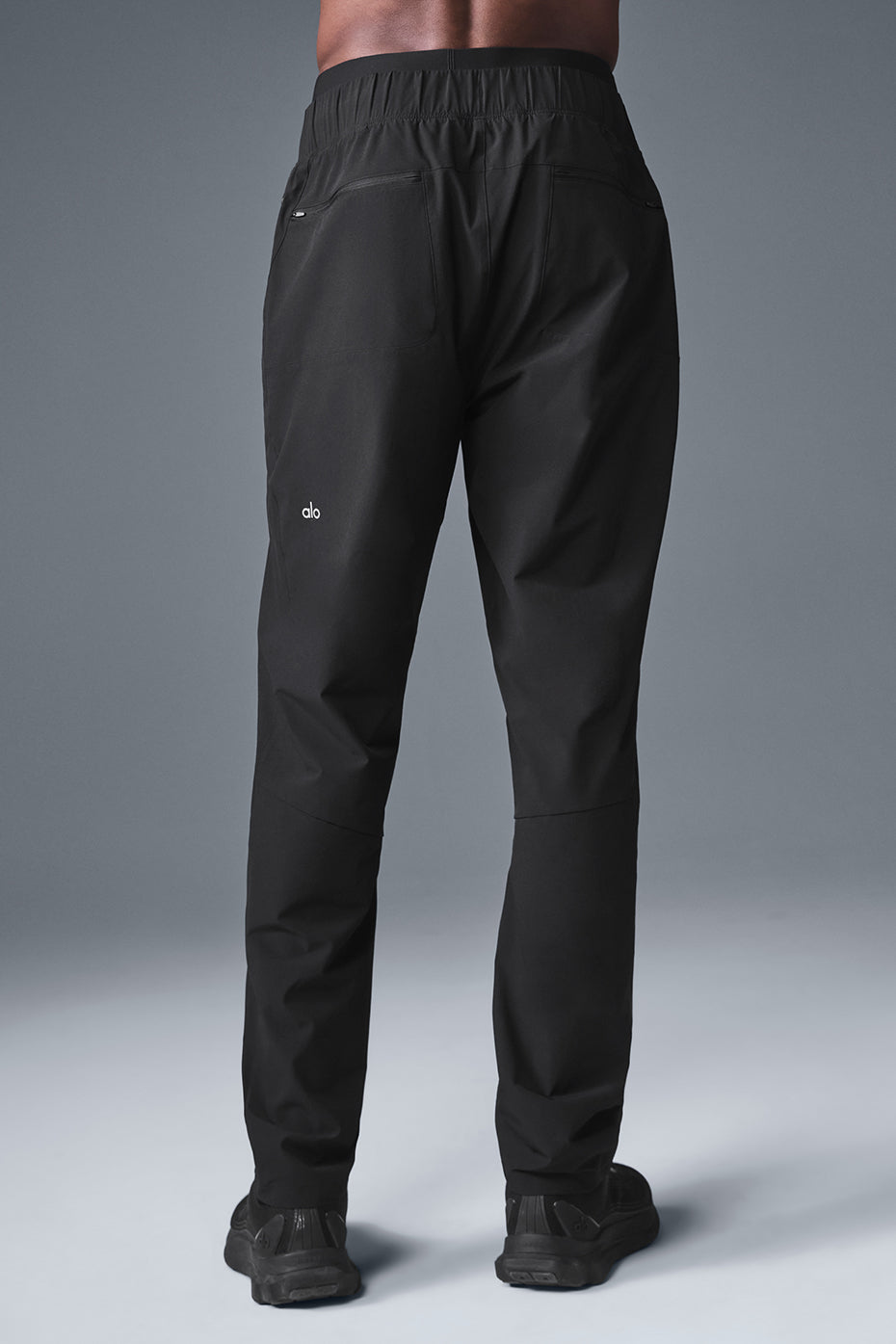 Model wearing black joggers in a studio setting, ideal for workouts.