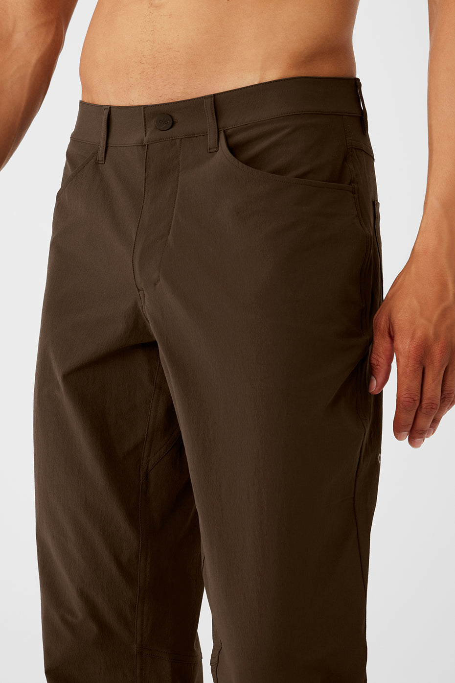 Close-up of espresso performance pants highlighting fabric texture and pocket details