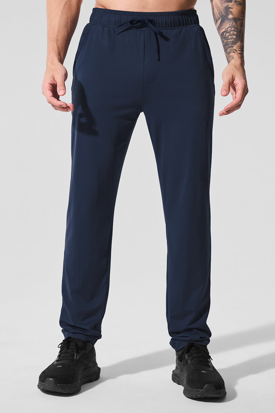 Navy Conquer Pulse Pant with zippered pockets on a model during workout
