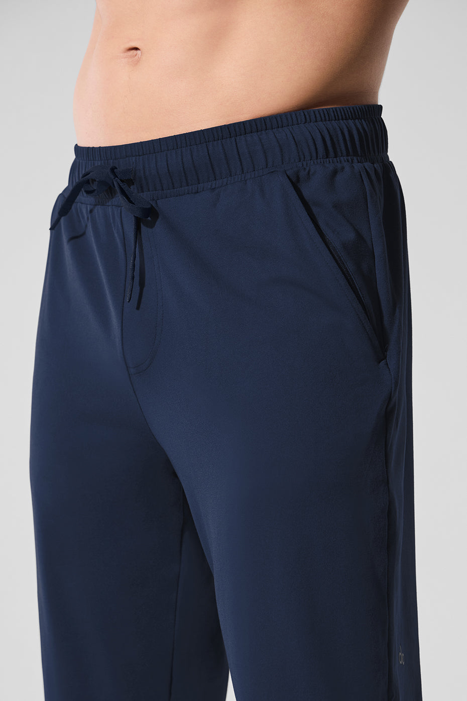 Navy Conquer Pulse Pant with zippered pockets on a model during workout