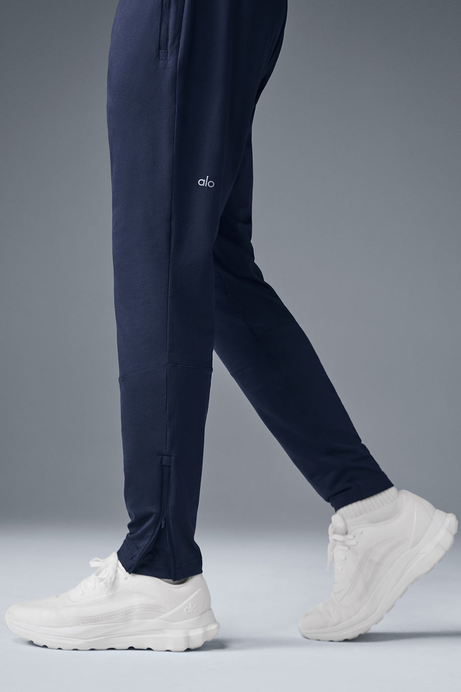 Model wearing navy Conquer React Performance Pants during outdoor workout