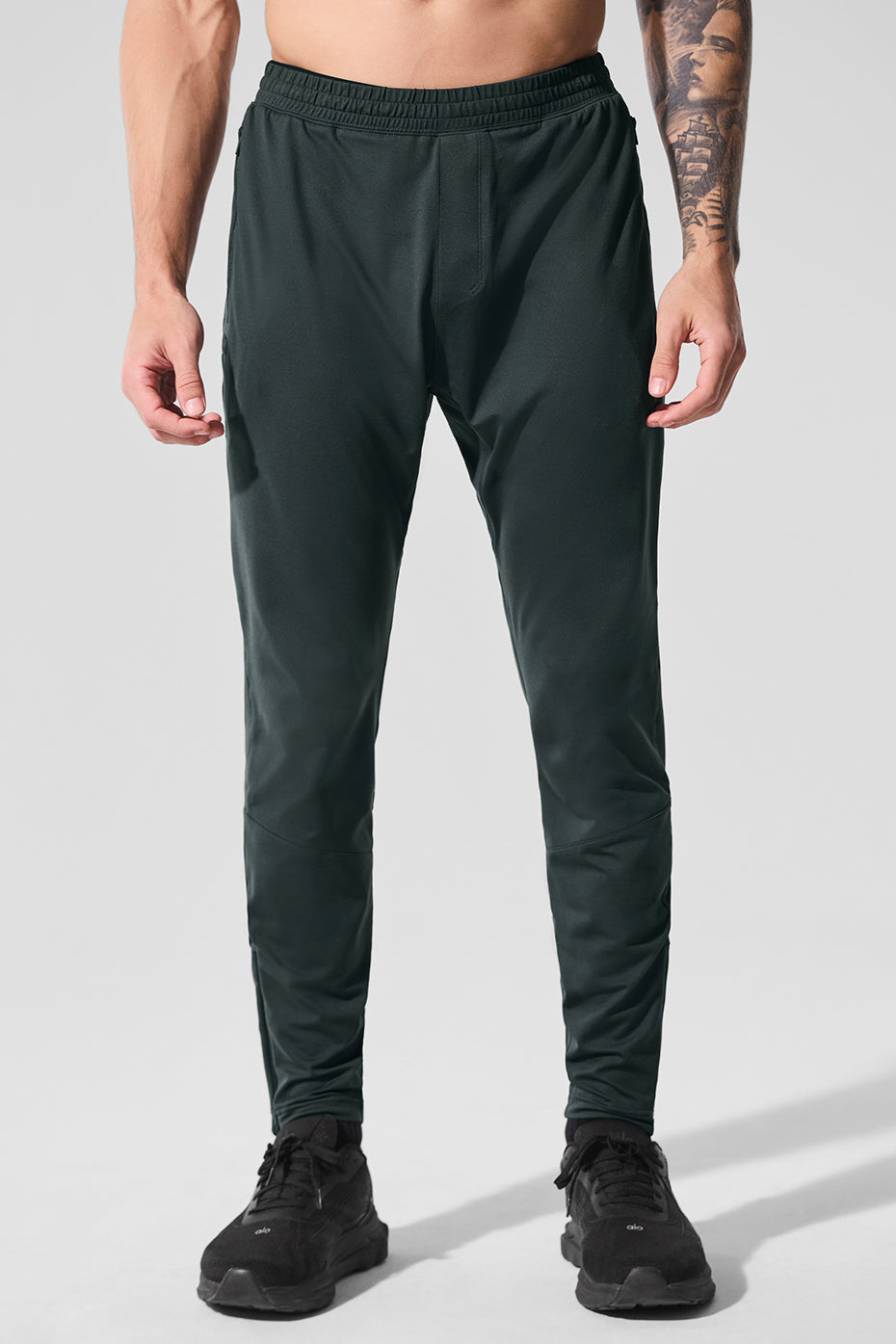 Side view of men's workout pants in charcoal green, worn during HIIT session