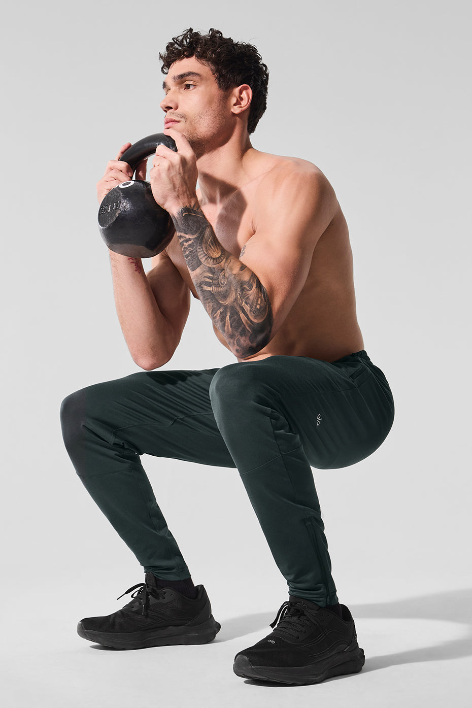 Close-up of Conquer fabric material on performance pants during stretch movement