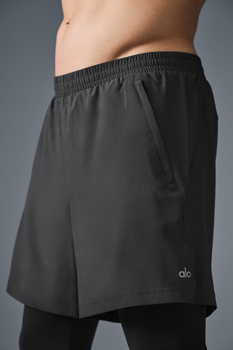 Front view of the Revival 2-in-1 running shorts on a woman stretching before a run.