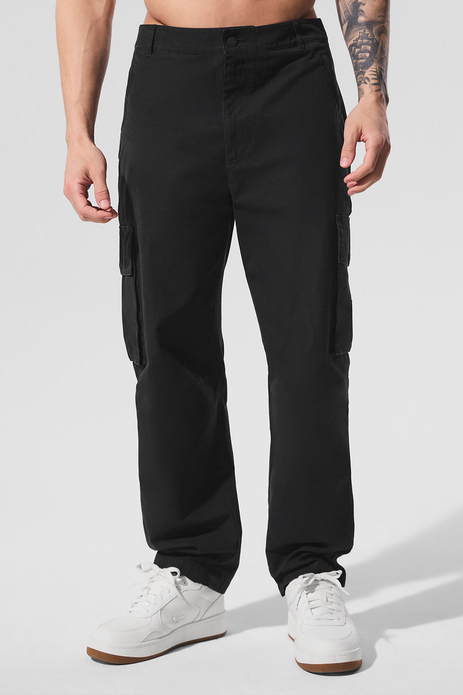 Front view of ripstop trousers worn with white sneakers on city pavement.