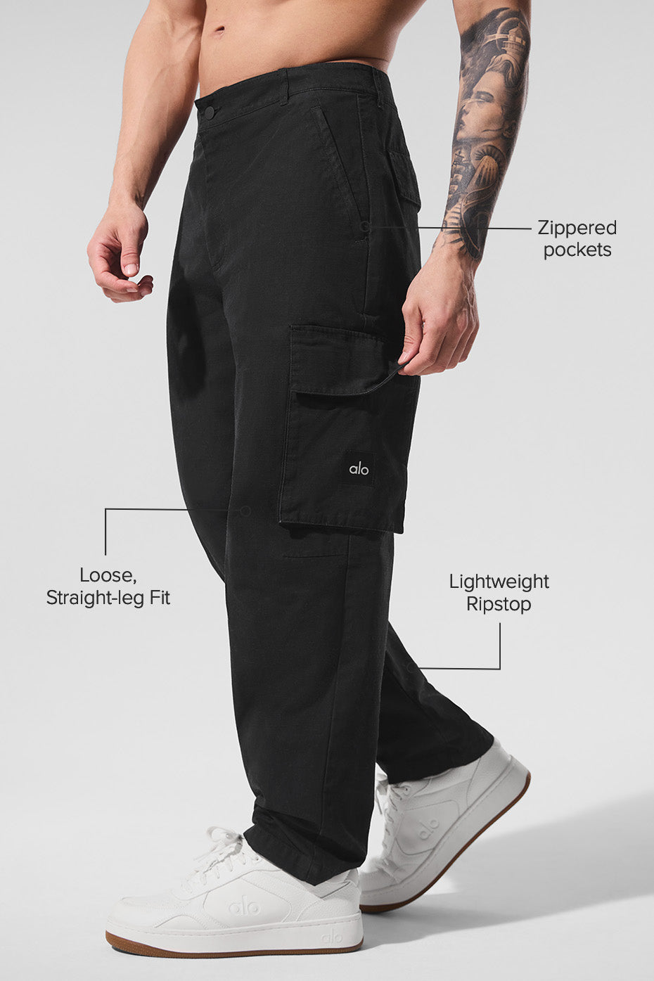 Close-up of cargo pocket detailing on black cargo pants in natural lighting.