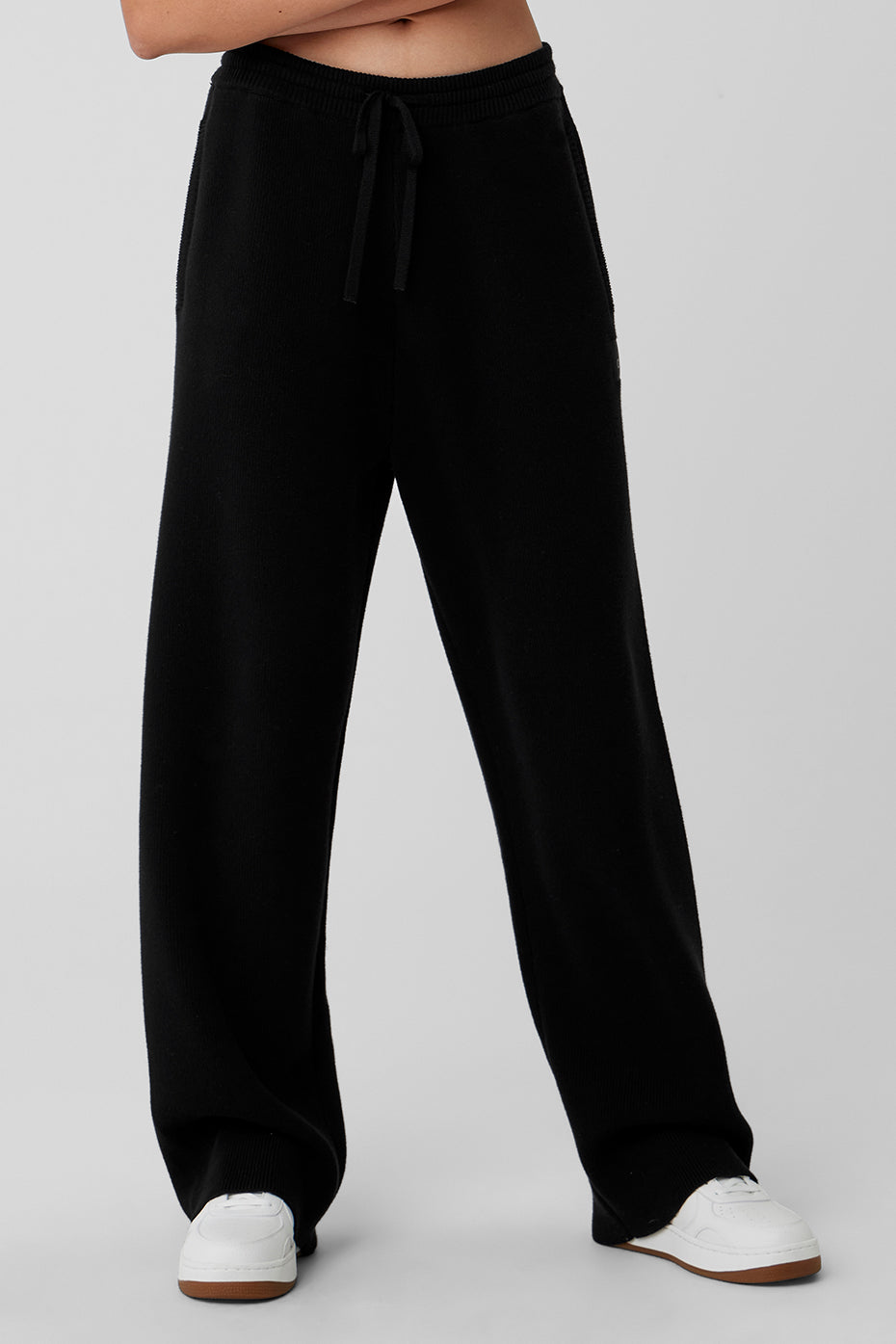 Front view of black wide leg sweatpants showcasing the drawcord and pockets.