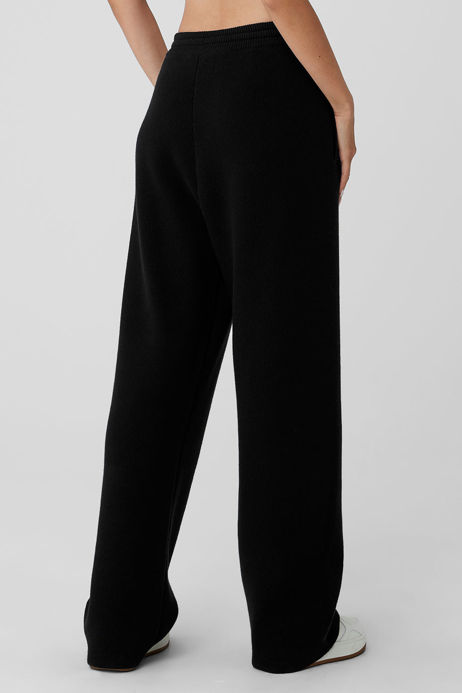 Side view of the black sweatpants highlighting the relaxed fit and fabric texture.