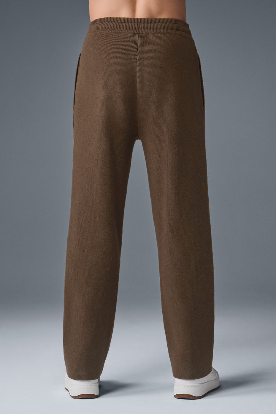 Close-up of knit joggers featuring a relaxed fit and functional zippers
