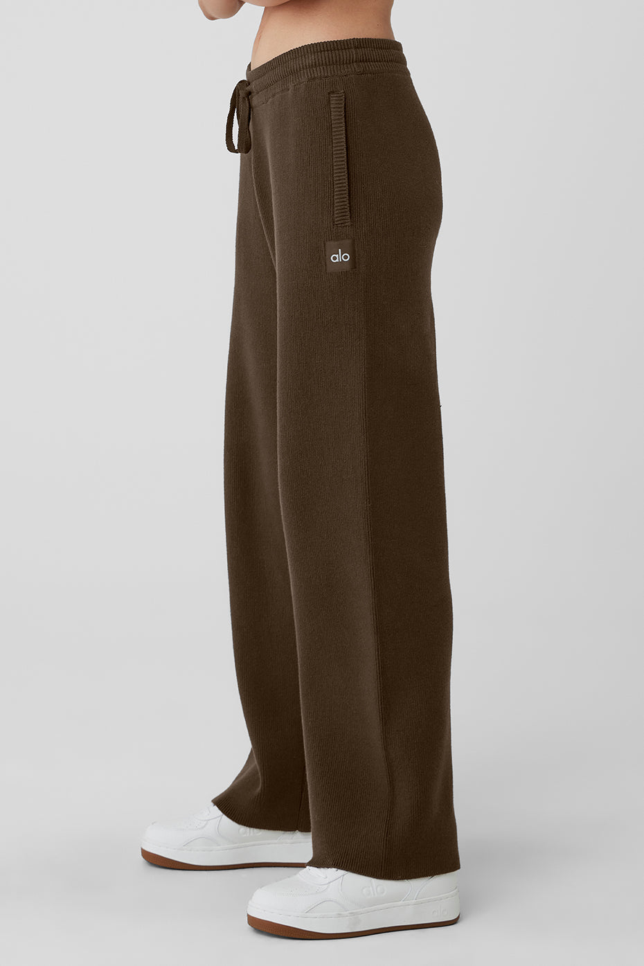 Model wearing grey sweatpants in a casual streetwear setting.