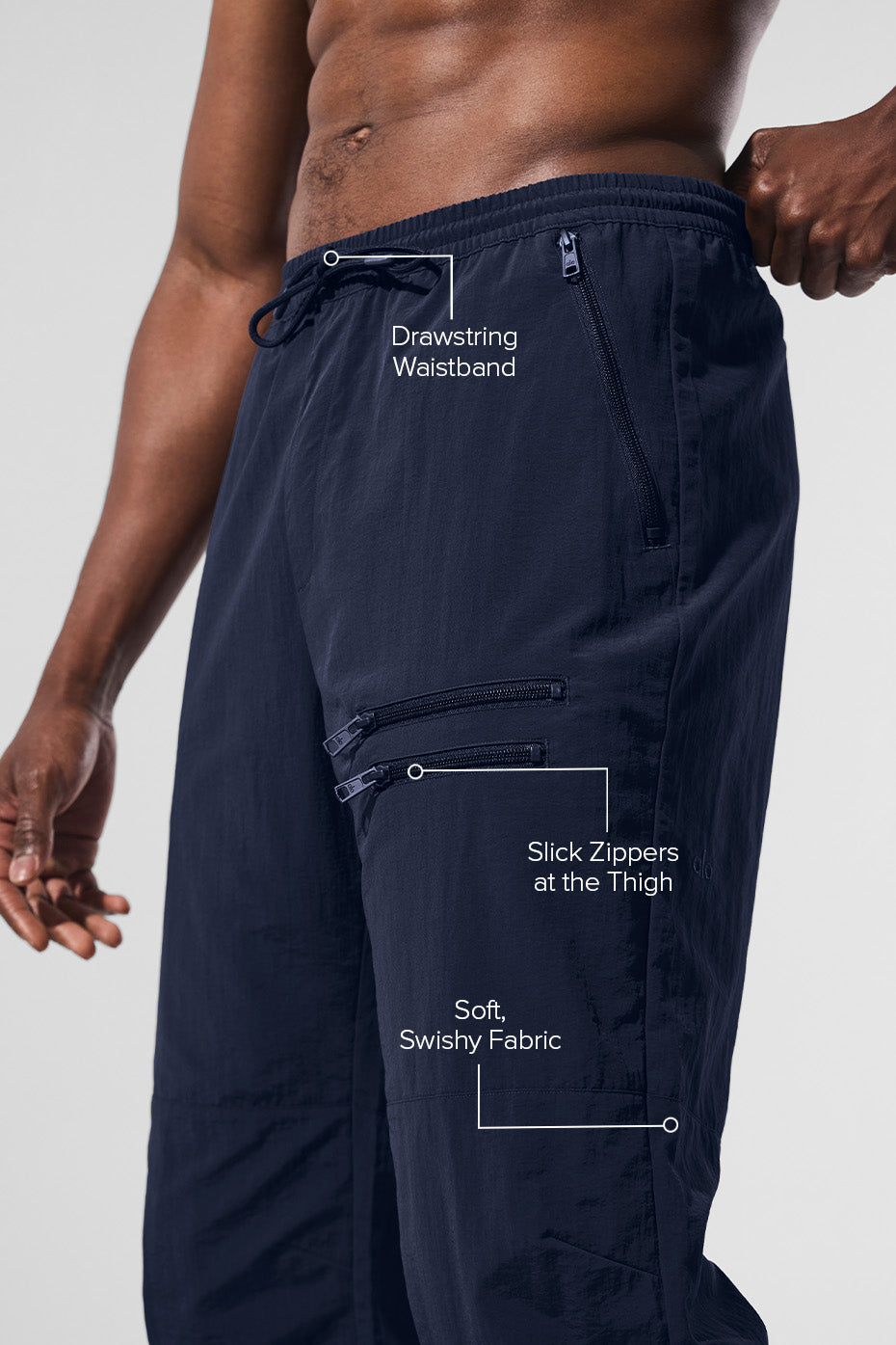 Model wearing navy track pants with adjustable bungee hems, suitable for gym or casual outings