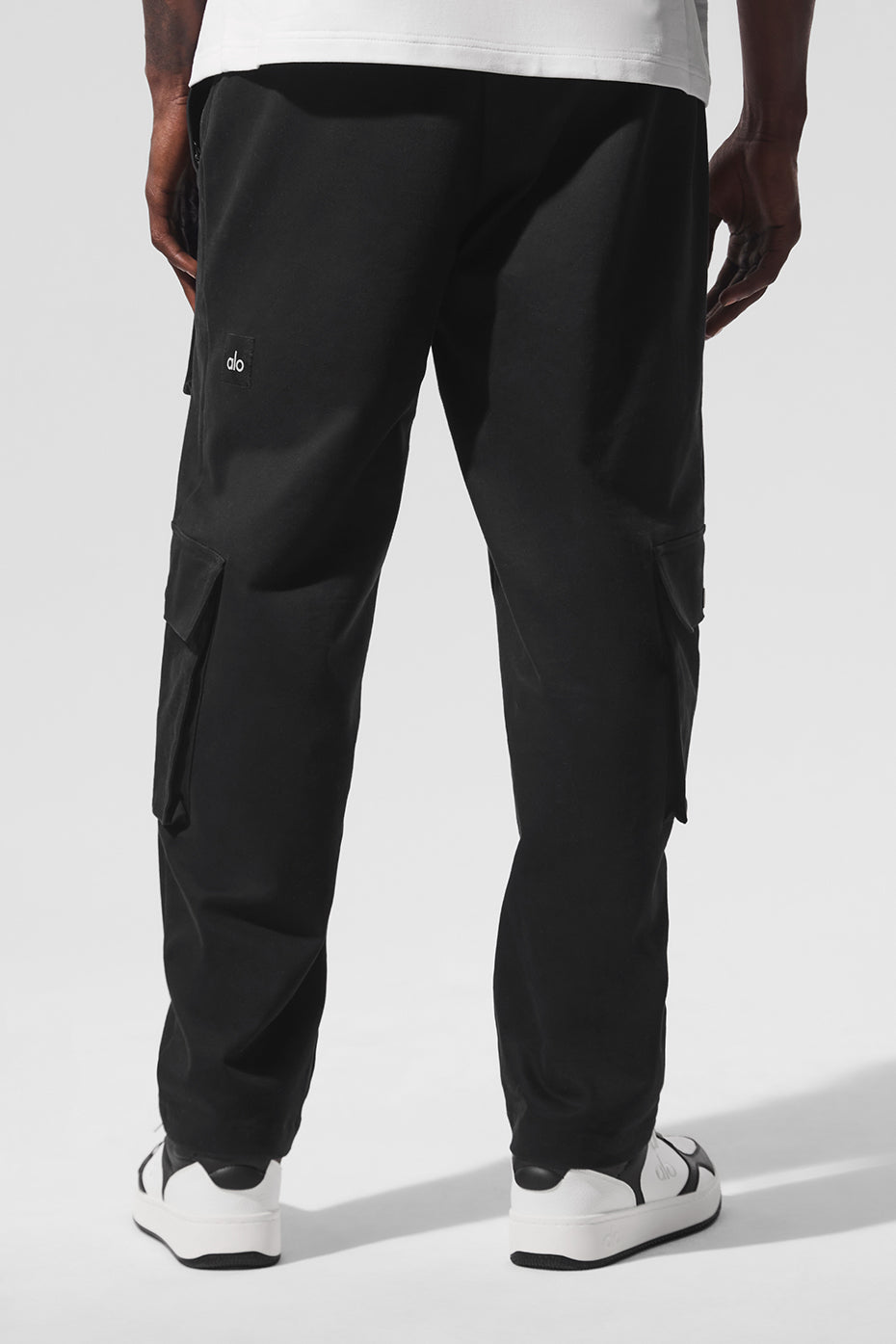 Casual outfit featuring black cargo pants paired with a hoodie and sneakers.