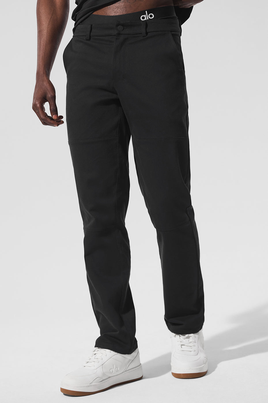 Black cotton twill pants laid flat showing sueded texture and tapered design