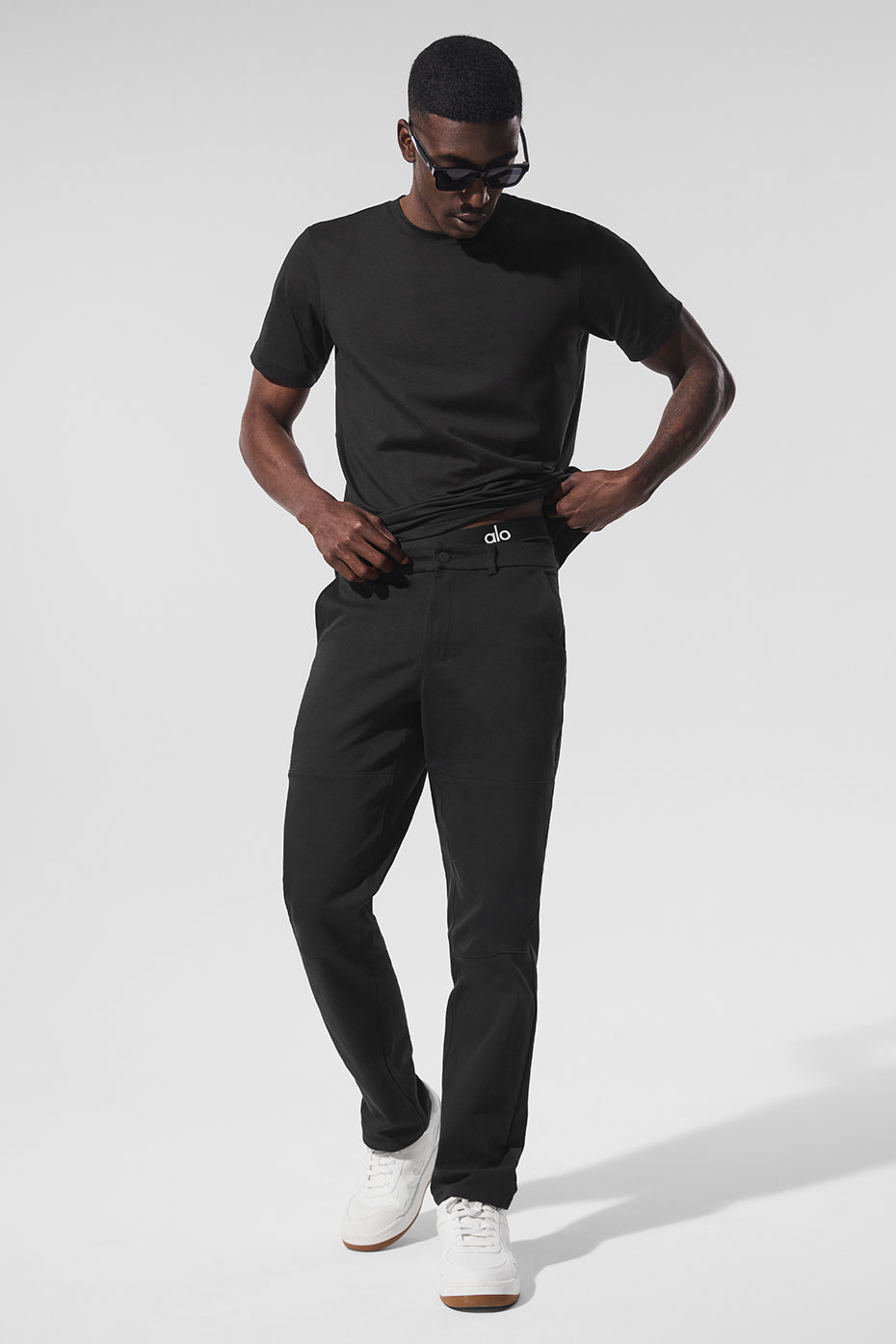Black cotton twill pants laid flat showing sueded texture and tapered design
