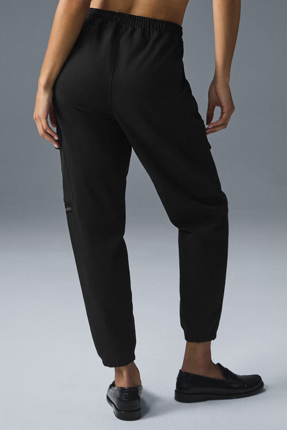 Model wearing black jogger pants in a casual outdoor setting.