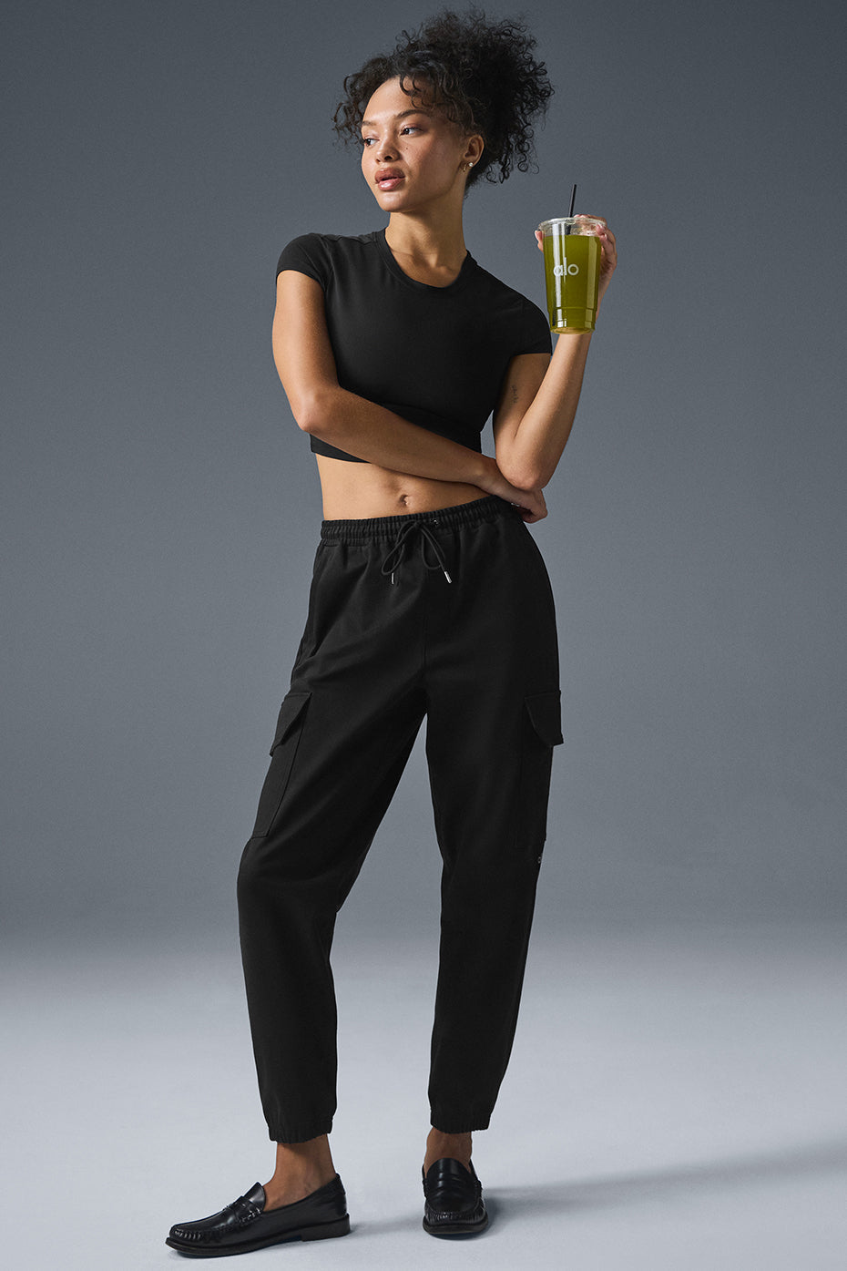 Model wearing black jogger pants in a casual outdoor setting.
