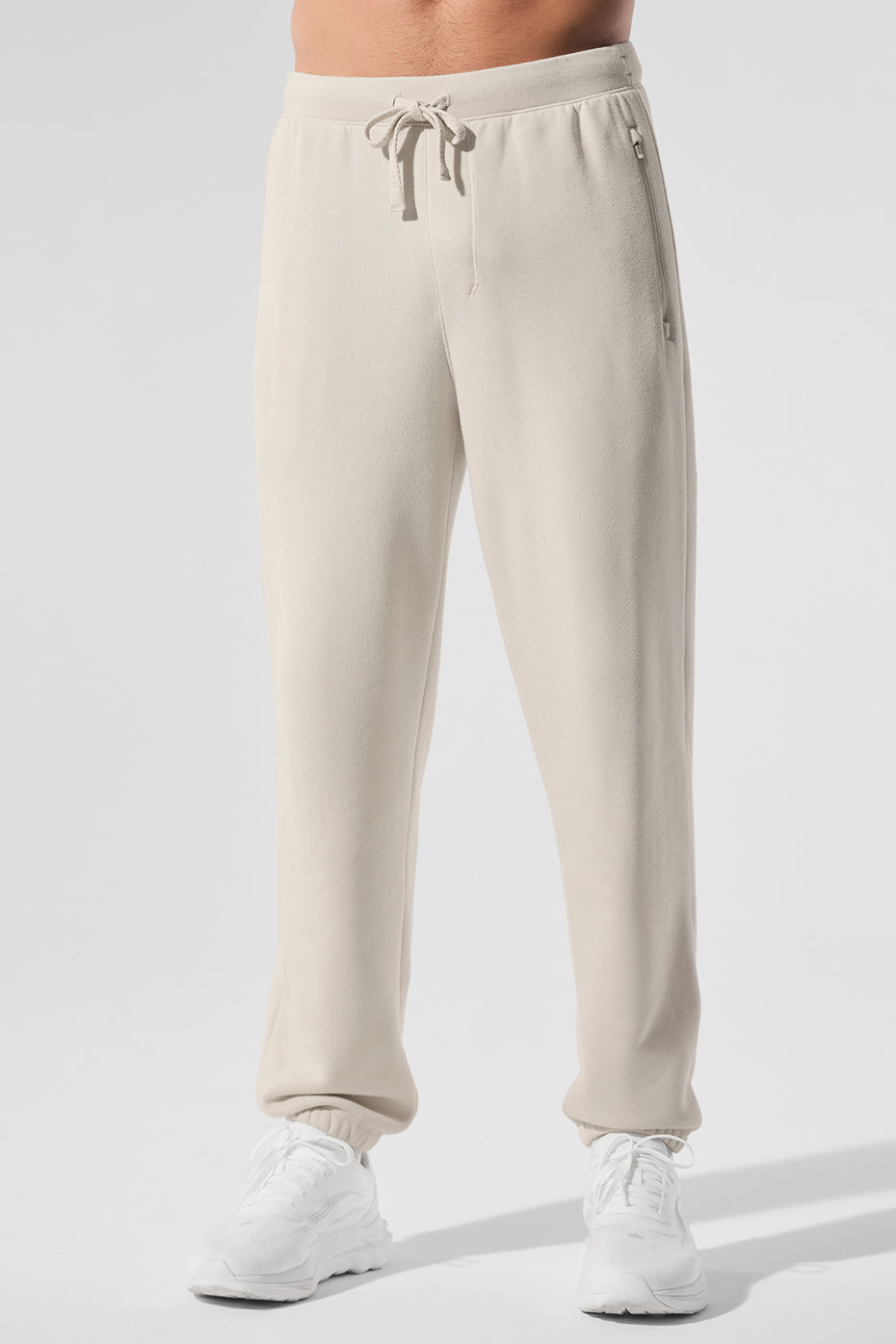Front view of baggy sweatpants styled with white sneakers and crew neck hoodie