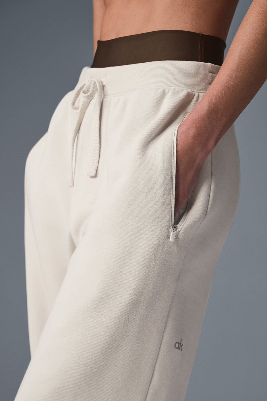 Side view of grey sweatpants with zippered pockets, perfect for activewear.