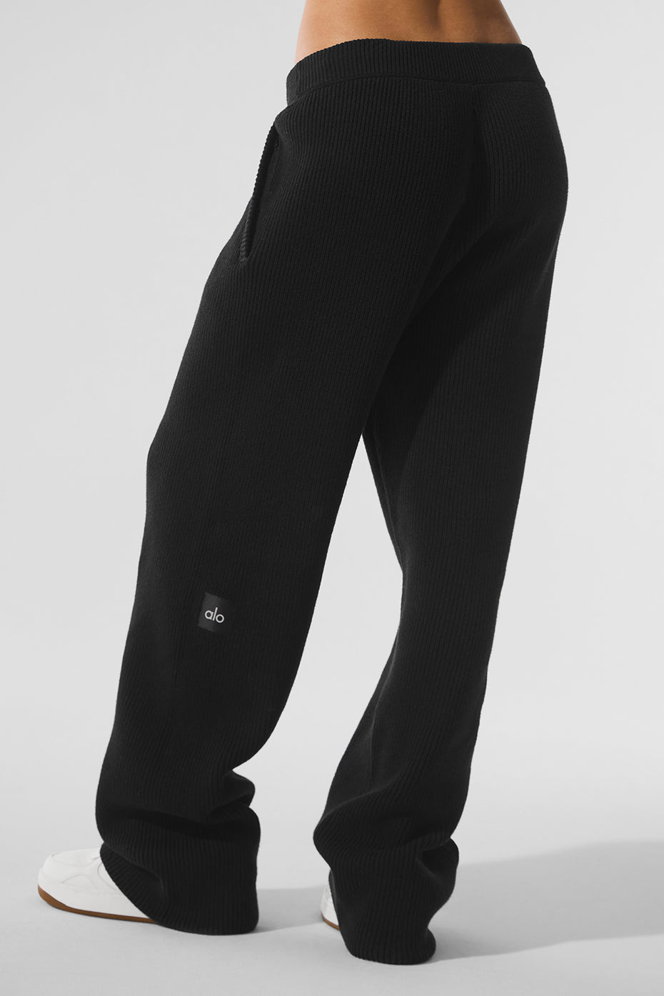 Model wearing black joggers during a relaxed home setting.