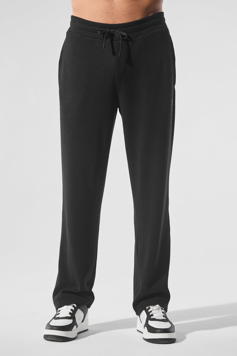 Elevate black waffle straight leg pants showcased on a mannequin.