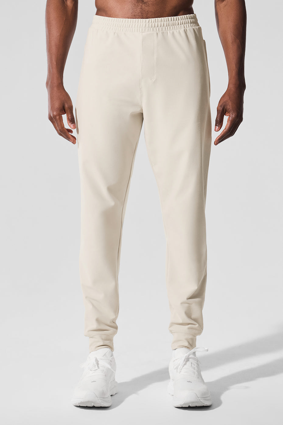 Close-up of men's performance joggers in Bone color highlighting stretchy fabric