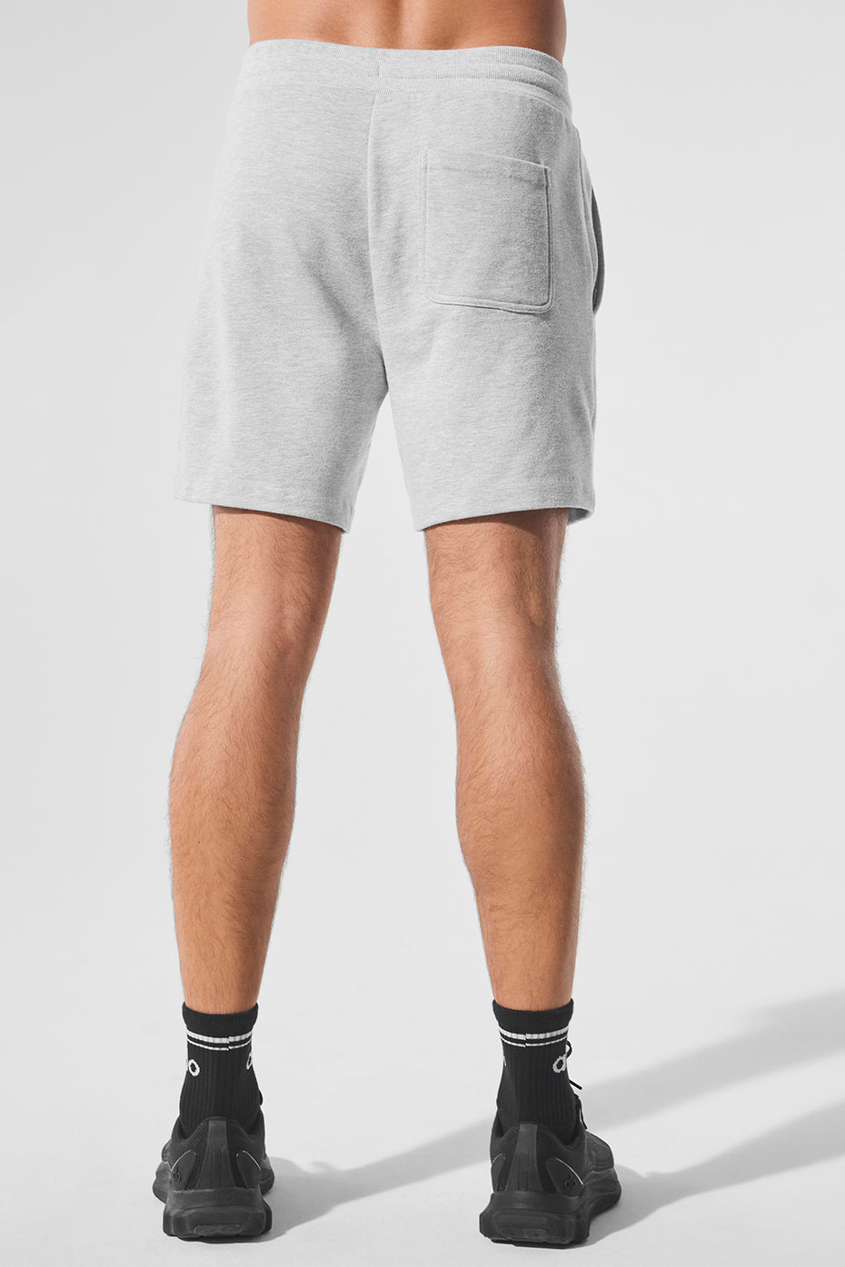 Model wearing athletic shorts outdoors, showcasing side pockets