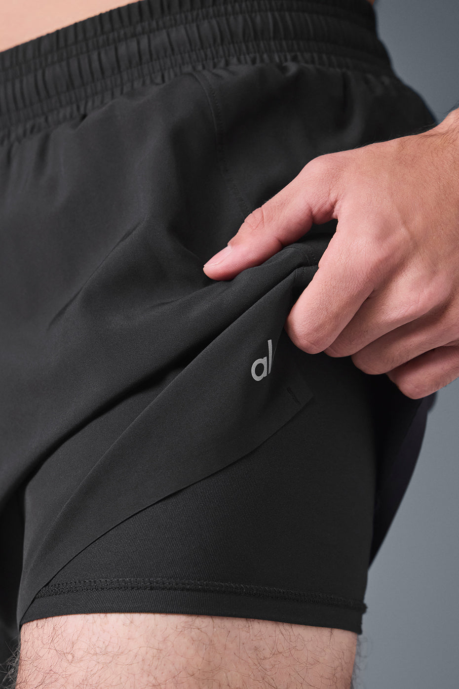 Side view of mens athletic shorts, highlighting the elastic waistband and drawcords.