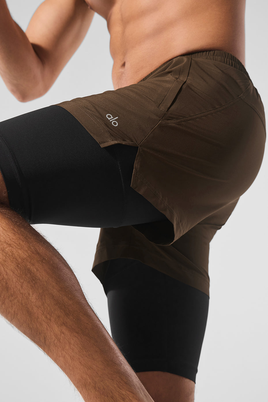 Back view of the Revival 2-in-1 running shorts, showing the zippered pockets and knee-length design.