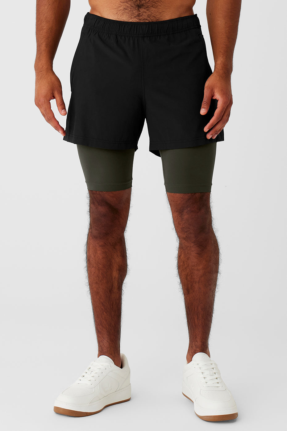Front view of black and green Revival 2-in-1 shorts with elastic waistband and zippered pockets