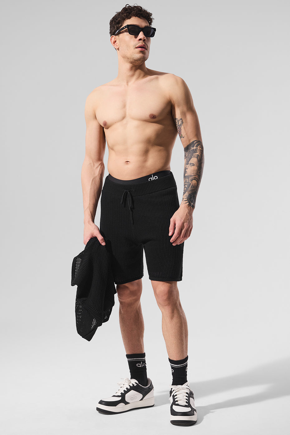 Front view of black open-knit swim shorts for women, perfect for beach days.