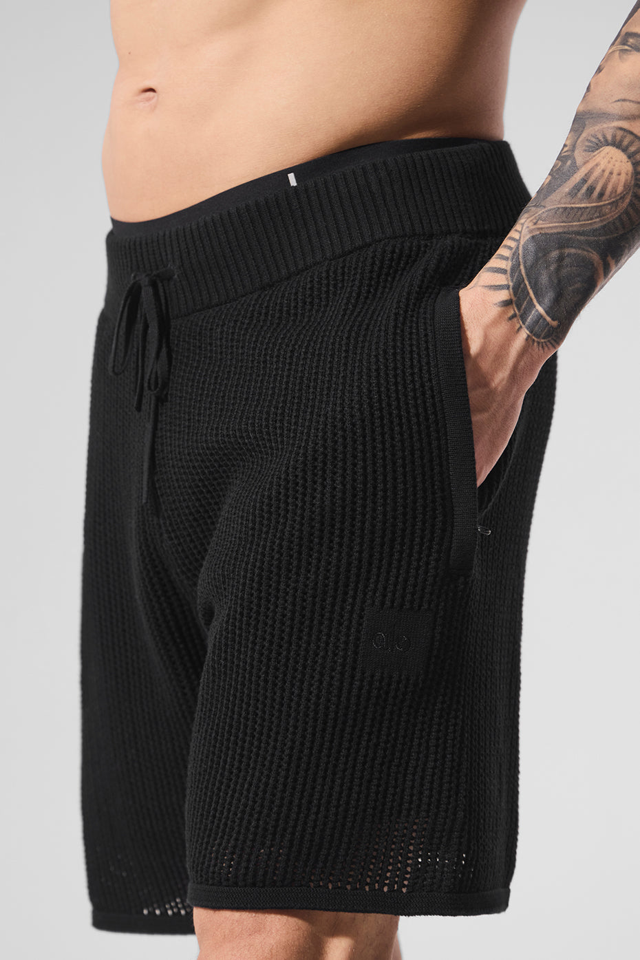 Model wearing lightweight swim shorts by the pool, showcasing comfort and style.