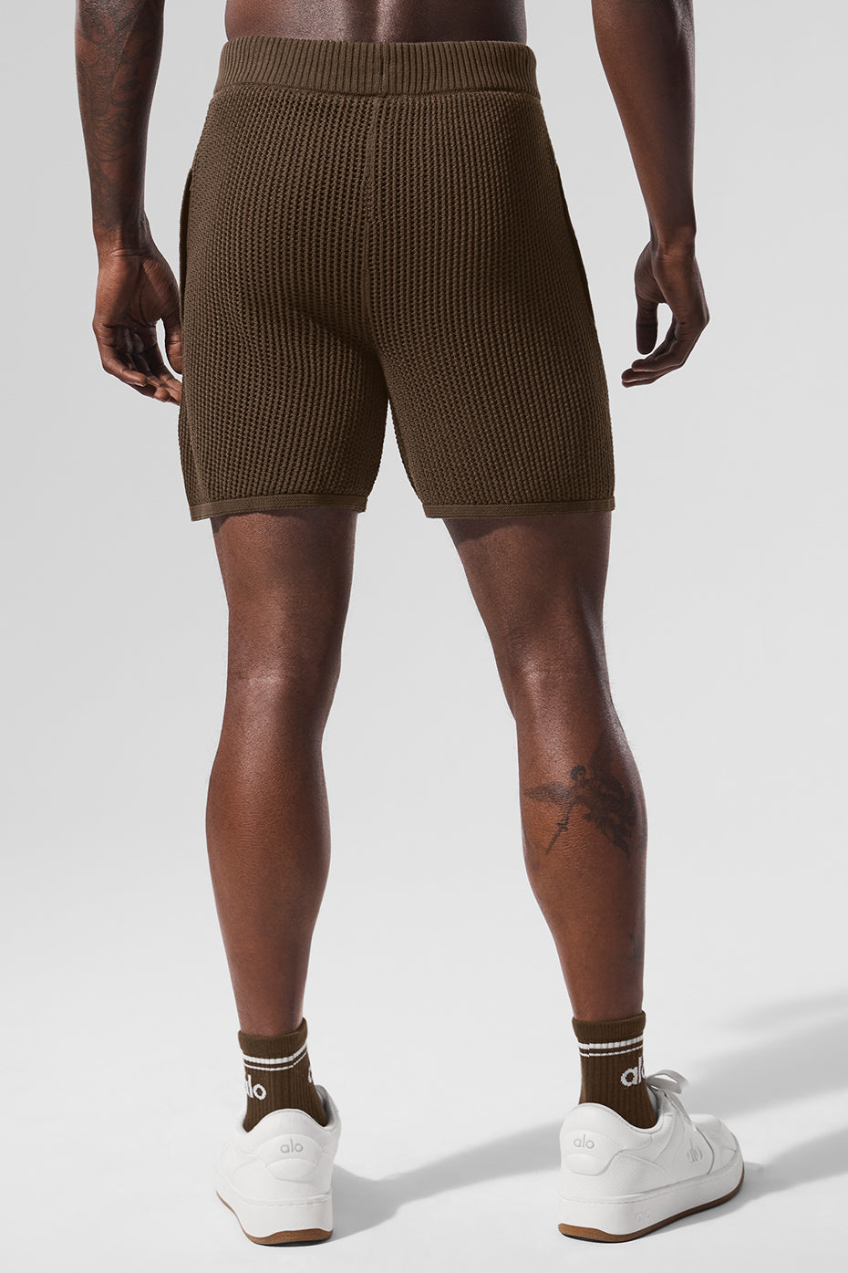Flat-lay image of open-knit shorts, inner liner visible for performance detailing
