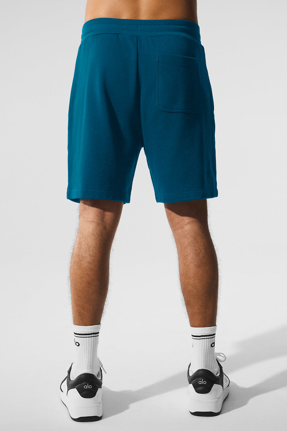 Man wearing Eclipse Blue lounge shorts while relaxing at home, emphasizing comfort.