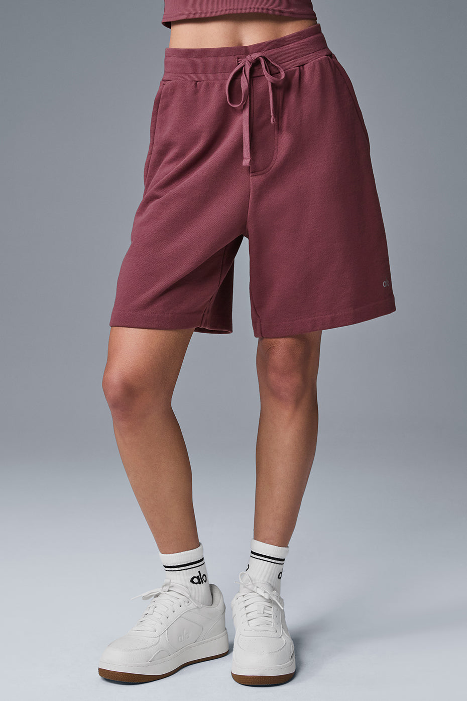 Women wearing burgundy lounge shorts at home, relaxing on the sofa