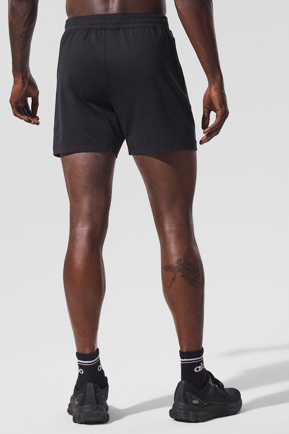 Athlete mid-run wearing black Conquer performance shorts outdoors