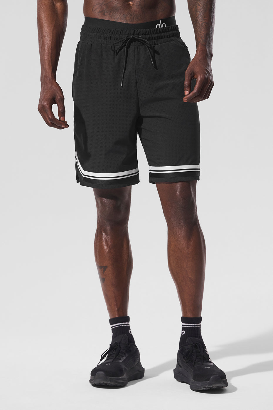 Close-up of perforated fabric on men's black running shorts