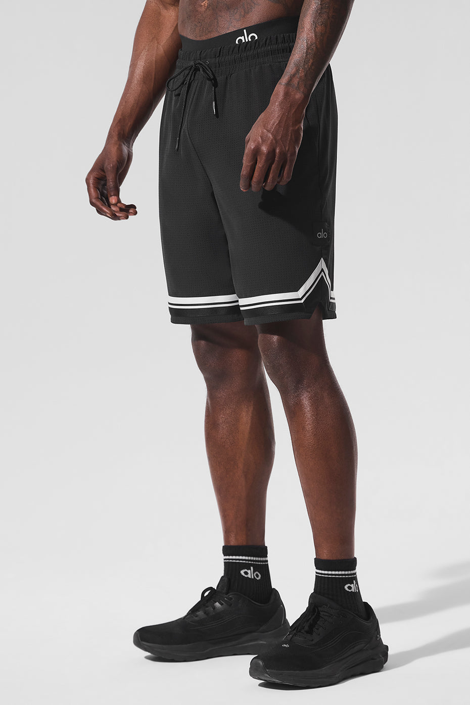 Close-up of perforated fabric on mens black running shorts
