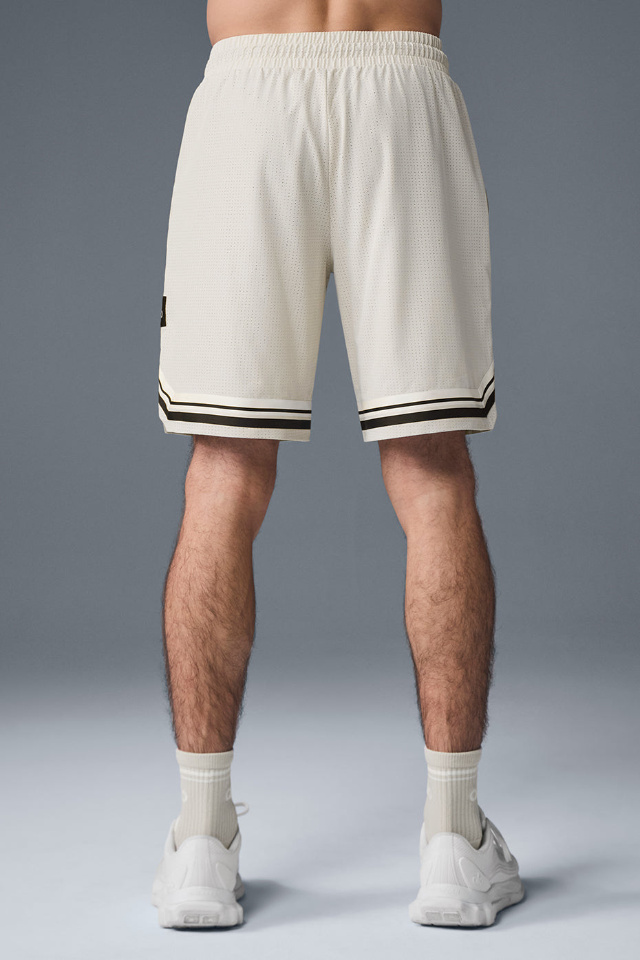 Side view of mens running shorts, highlighting adjustable drawcord and zip pockets.