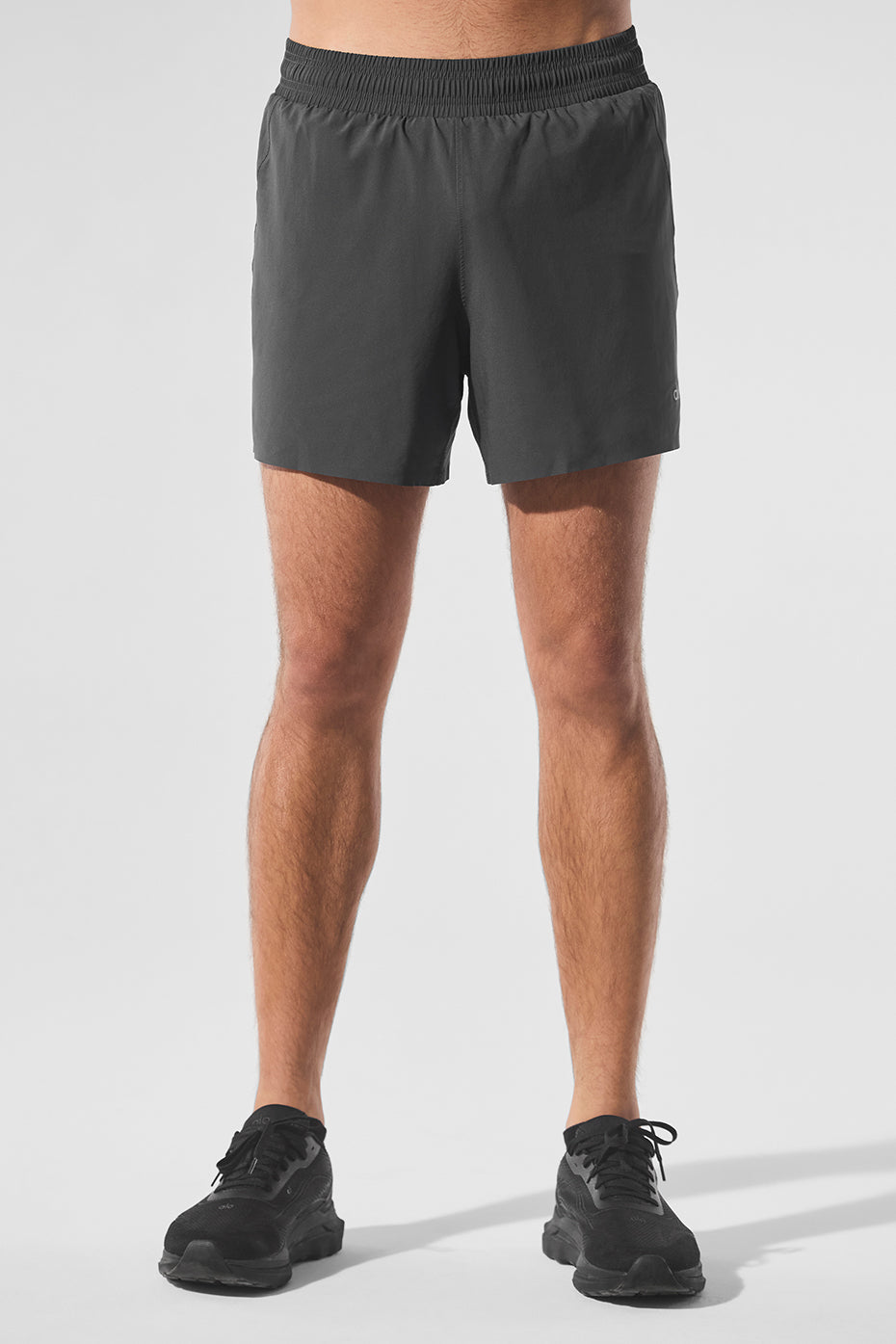 Front view of AdaptFlex 5 inch shorts on male runner mid-stride near Brooklyn Bridge.