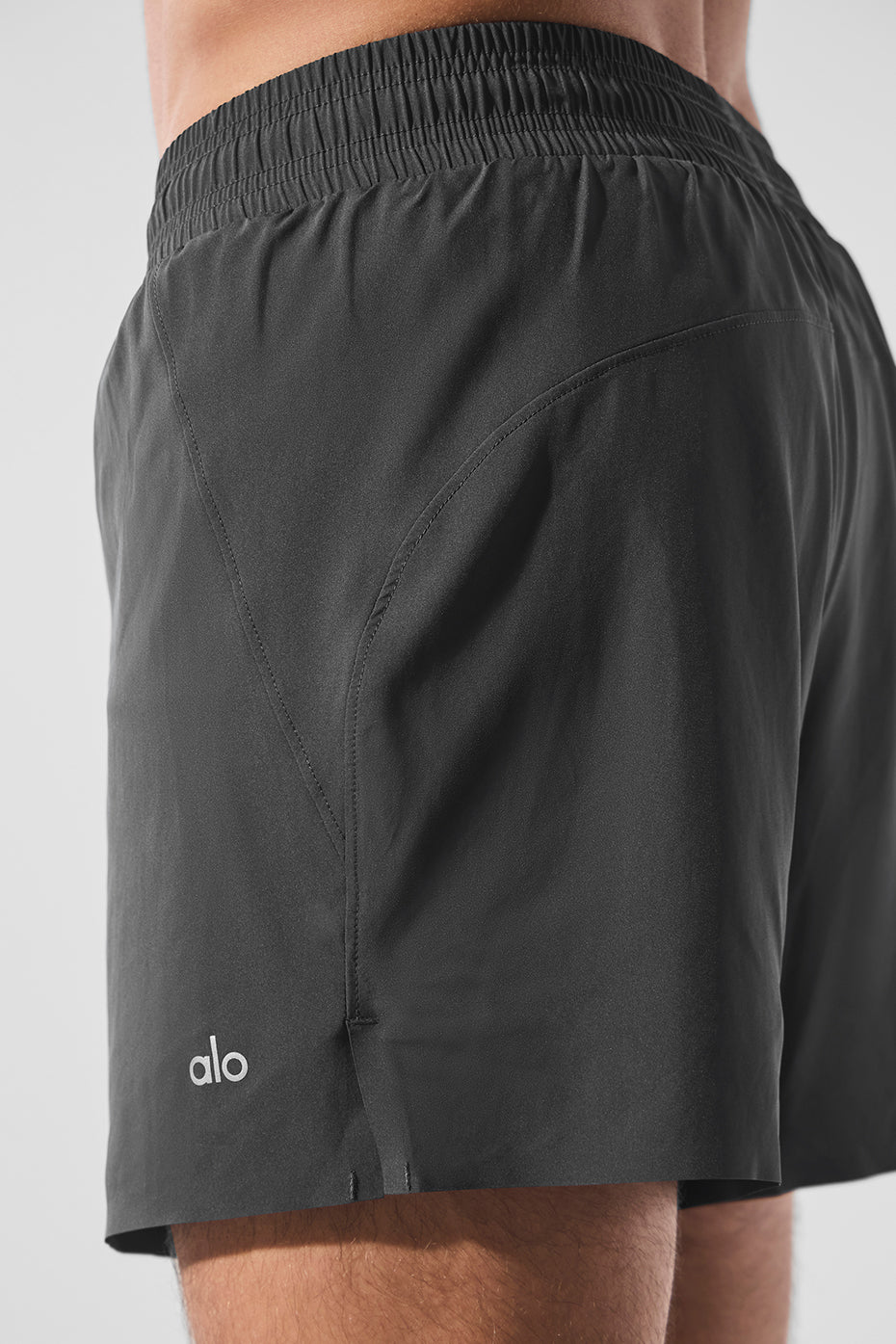 Front view of AdaptFlex 5 inch shorts on male runner mid-stride near Brooklyn Bridge.