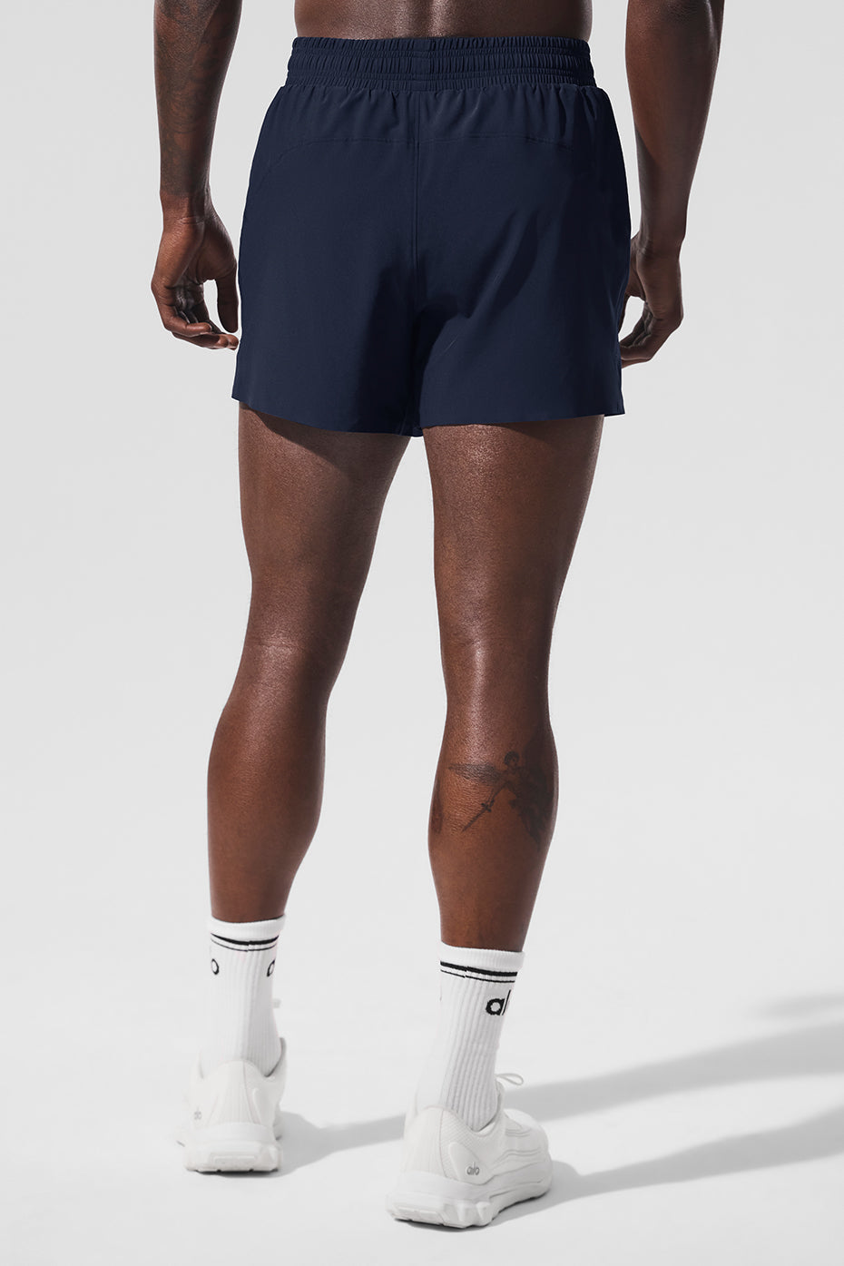 Men’s navy 5-inch running shorts on a runner mid-stride.