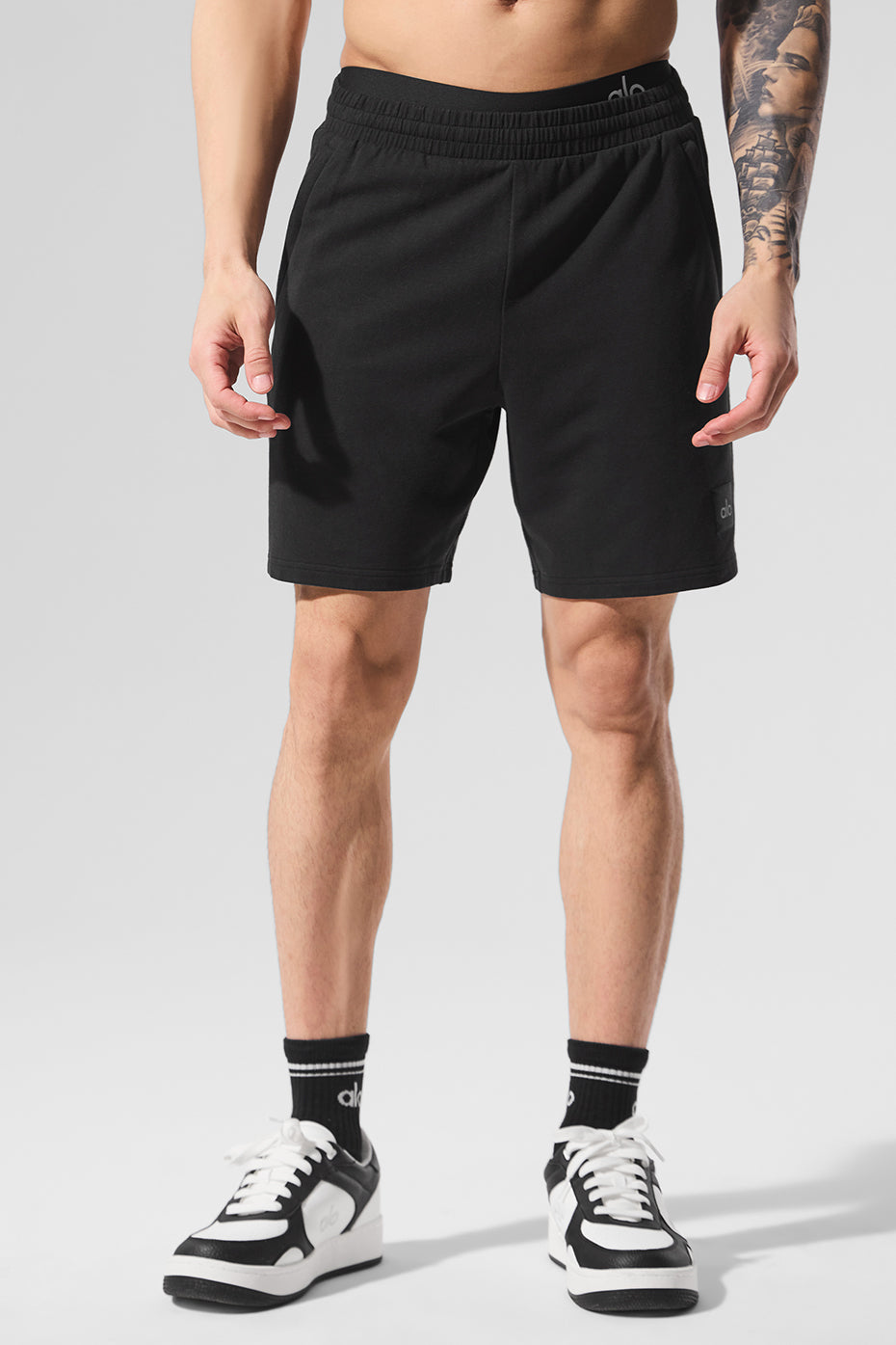 Front view of jet black shorts styled with an oversized hoodie for casual streetwear look.