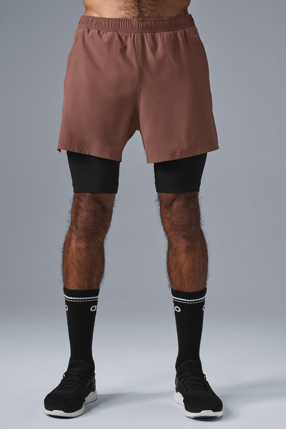Front view of Revival 2-in-1 performance shorts in chestnut and black, showcasing the outer shell and inner compression shorts.