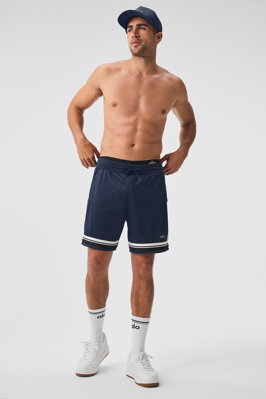 Front view of mens mesh shorts in navy, styled with athletic sneakers