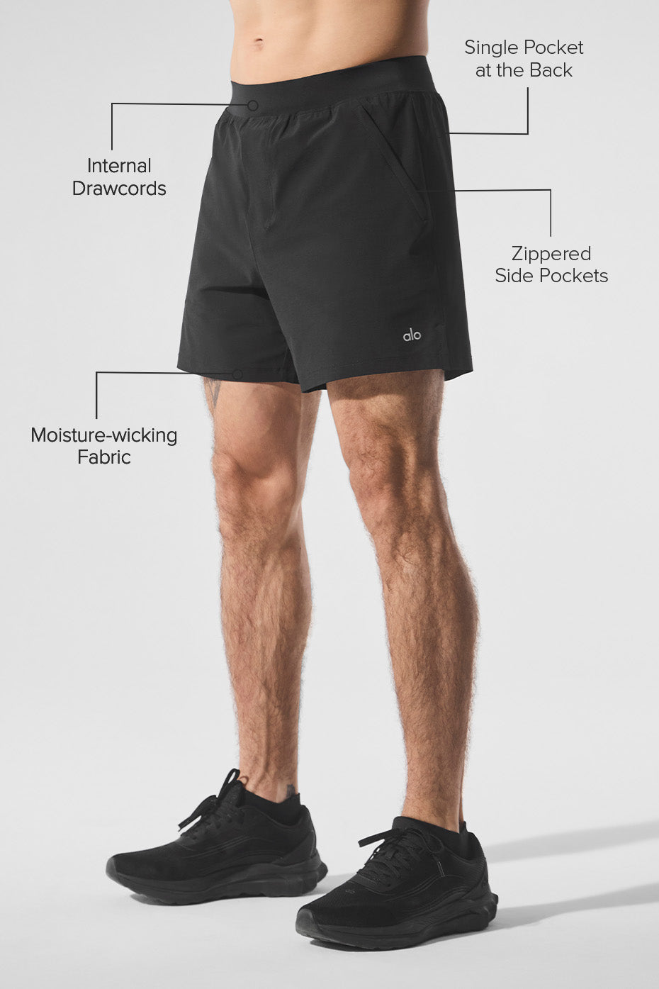 Model wearing black gym shorts men style on city sidewalk